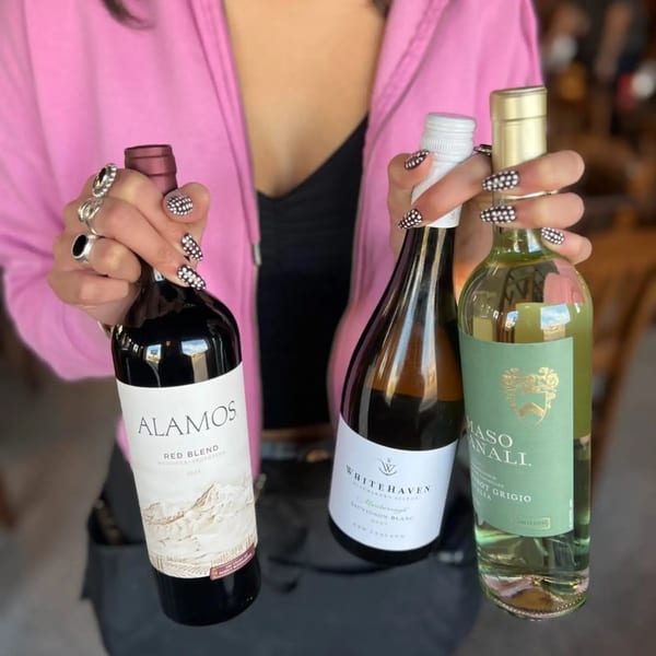 Three wine bottles, including Alamos Red Blend, Whitehaven Sauvignon Blanc, and Maso Canali Pinot Grigio.