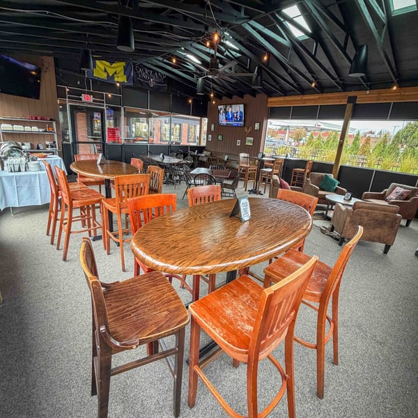 Spacious Firebird Tavern dining area with high-top tables, bar stools, and lounge seating under a vaulted ceiling.