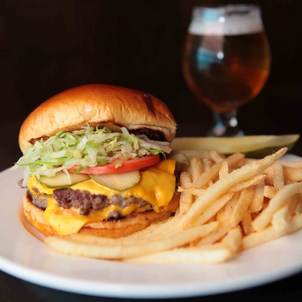 Firebird Tavern's double cheeseburger with fries, a pickle spear, and a beer.
