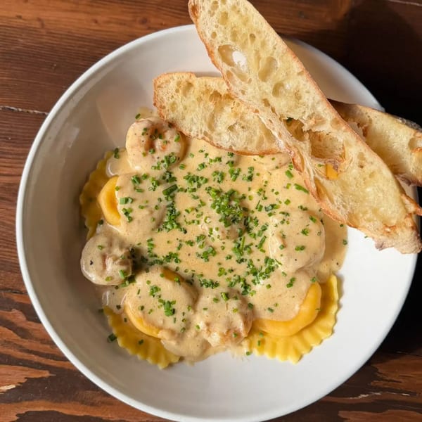 Firebird Tavern's ravioli with creamy sauce, shrimp, chives, and toasted baguette slices.