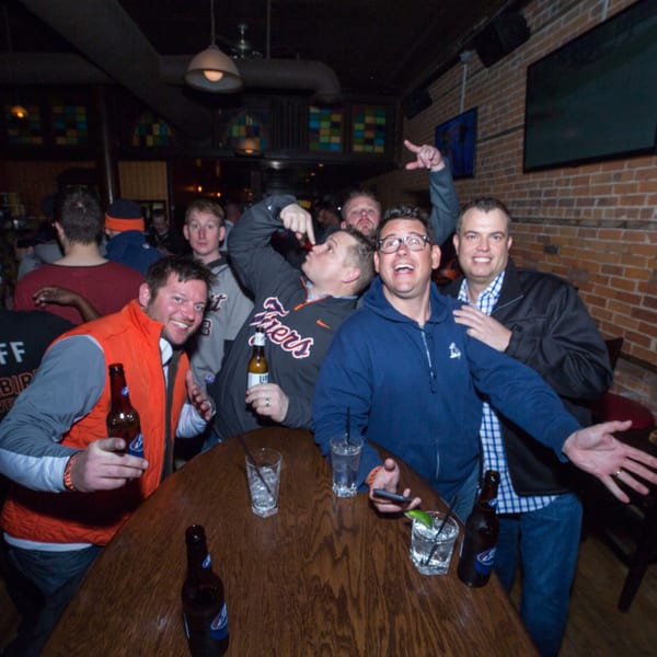 Group of men laughing and posing for a photo at a Firebird Tavern bar.